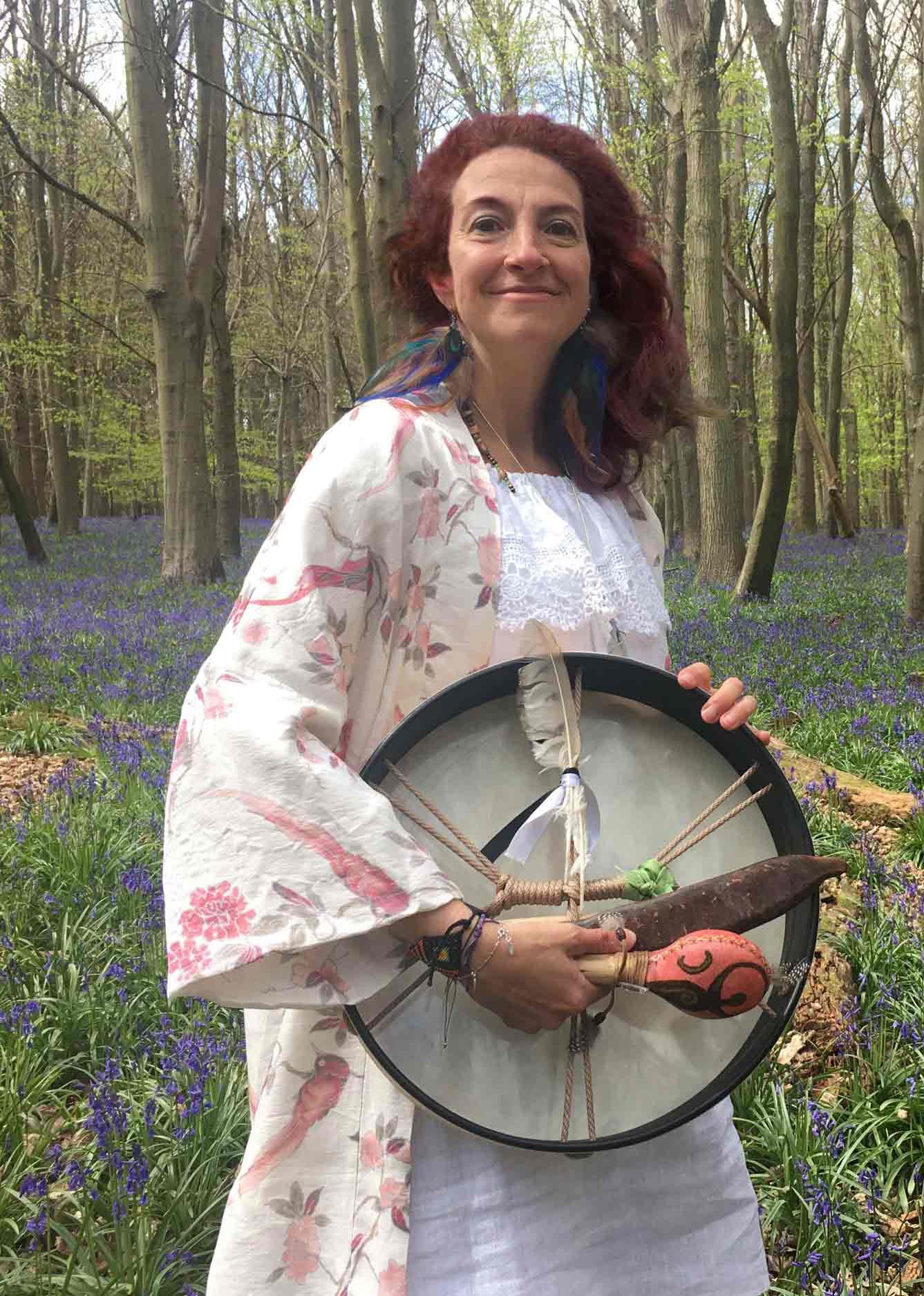 Gloria Urech holding medicine drum in the woods